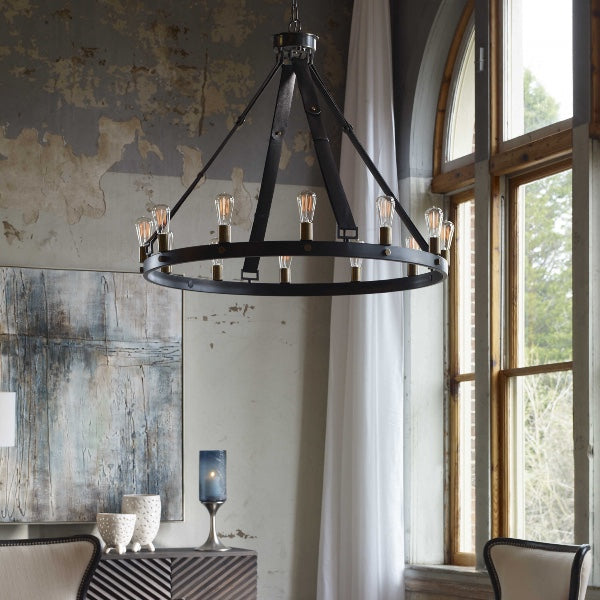 A modern chandelier featuring a metal and is hanging from four leather belts, and several vintage light bulbs are attached to the metal ring. There is a window in the room and some other decorative elements.