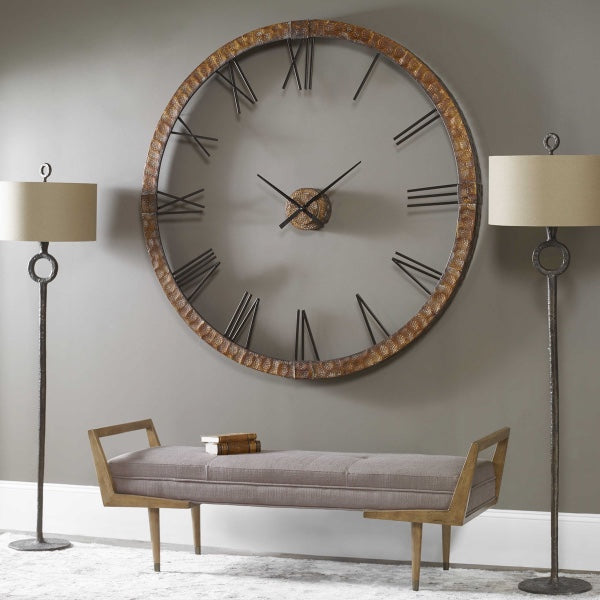 A large round wall clock, hanging on an olive green wall, a bench, and one lamp on each side of the bench to complete this modern space.