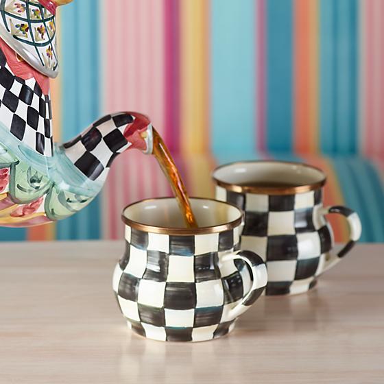 Coffee pot and mugs with a Courtly check pattern from Mackenzie Childs, and a couch with pastel colors strip on the background