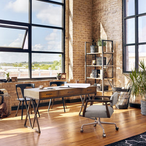 An office room, a vintage wood desk, brick walls and a large window allowing the sun light to get into the room