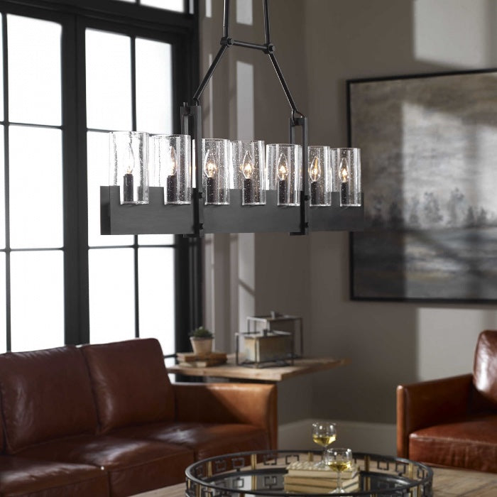 An island light fixture with seven bulbs in a linear shape with a heavy, oversized transforms this living room in a  modern farmhouse & rustic or industrial look.