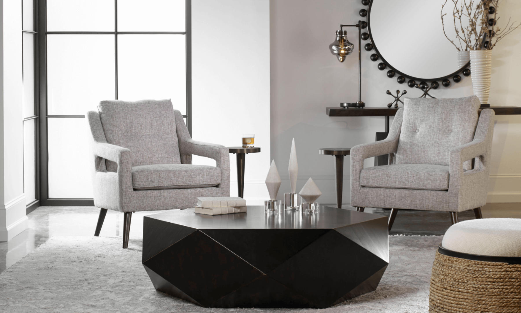 A modern living room, with two accent chairs, a minimalistic coffee table, and a beautiful white/grey rug