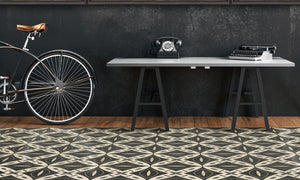 A vintage decorated room with a large vintage vinyl floor mat, a desk on the back with a vintage phone and typewriter and a vintage bike next to it