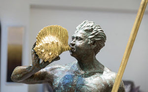 A sculpture of a Greek God, half man half fish holding a triton