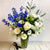 A sympathy flowers arrangement with white roses and purples