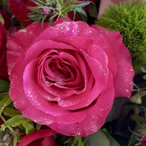 A Jaw-dropping floral design that showcases the pure beauty of a rose. A stunning arrangement of paved mixed roses and greens. Featuring red hearts roses. Pink Floyd Roses and romantic O'Hara garden roses. Topped with a touch of glitter.