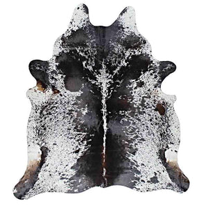 A Cowhide Rug in white with several black chunks, like Salt & Pepper